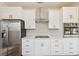 Modern kitchen featuring stainless steel refrigerator, white cabinets and backsplash and stainless hood at 502 W Hanna Ave, Tampa, FL 33604