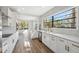 Bright kitchen features white cabinets, stainless steel appliances, quartz countertops, and a view to the backyard at 502 W Hanna Ave, Tampa, FL 33604
