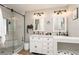 Well-lit bathroom featuring a walk-in shower, dual sink vanity, and modern finishes at 5441 Worthington Loop, Palm Harbor, FL 34685