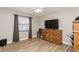 Neutral colored bedroom with hardwood floors, window with curtain, flat screen television and furniture at 5441 Worthington Loop, Palm Harbor, FL 34685