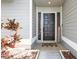 The entryway of this beautiful home features a dark wood door and decorative landscaping at 5441 Worthington Loop, Palm Harbor, FL 34685