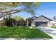 Charming single-story home boasts a well-manicured lawn, mature trees, and an inviting front entrance at 5441 Worthington Loop, Palm Harbor, FL 34685