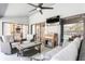 Outdoor seating area with comfortable furniture, ceiling fan, television, and sliding glass doors to the pool at 5441 Worthington Loop, Palm Harbor, FL 34685