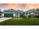 Charming single-story home with a well-manicured lawn, a two-car garage and a picturesque sky in the background at 59 Mark Twain Ln, Rotonda West, FL 33947