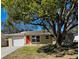 Charming single-story home featuring a bright red front door, mature landscaping and a one car garage at 6733 Carnelian Ave, New Port Richey, FL 34653