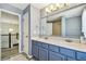 Bathroom with double sink vanity, updated tile, modern lighting, and a tiled shower reflected in the mirror at 7309 Night Heron Dr, Land O Lakes, FL 34637