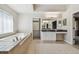 Bright bathroom with a soaking tub, double vanity, and a walk-in closet with custom storage at 7309 Night Heron Dr, Land O Lakes, FL 34637