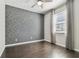 Bedroom with hardwood floors, modern accent wall, and natural light at 7309 Night Heron Dr, Land O Lakes, FL 34637