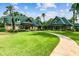 Community clubhouse featuring a walkway, well-manicured lawn, and lush landscaping at 7309 Night Heron Dr, Land O Lakes, FL 34637