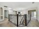 Upstairs hallway featuring an open railing, chandelier, and views into adjacent rooms at 7309 Night Heron Dr, Land O Lakes, FL 34637