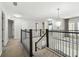 Upstairs hallway featuring stylish railing, neutral carpet, and multiple doorways providing access to various rooms at 7309 Night Heron Dr, Land O Lakes, FL 34637