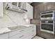 Modern kitchen with stainless steel appliances, sleek cabinets, and marble countertops with a modern range hood at 7309 Night Heron Dr, Land O Lakes, FL 34637