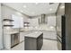 Modern kitchen featuring white cabinets, stainless steel appliances, and a central island with marble countertops at 7309 Night Heron Dr, Land O Lakes, FL 34637