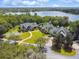 Aerial view featuring lakefront community buildings with lush landscaping at 7309 Night Heron Dr, Land O Lakes, FL 34637