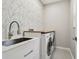 Laundry room featuring a stainless steel utility sink, butcher block counter, and washer/dryer at 7309 Night Heron Dr, Land O Lakes, FL 34637