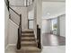 Staircase with plush carpet leading to the upper level, complemented by dark wood railings and modern design elements at 7309 Night Heron Dr, Land O Lakes, FL 34637