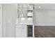 The wet bar features marble countertops, glass-front cabinets, a wine cooler, and stylish lighting at 7309 Night Heron Dr, Land O Lakes, FL 34637