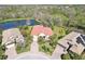 Aerial view of the property, highlighting the tile roof, pool, landscaping, and serene pond setting at 8057 Rio Bella Pl, Bradenton, FL 34201