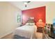 Bedroom features a red accent wall, a ceiling fan, and a window with blinds at 8057 Rio Bella Pl, Bradenton, FL 34201