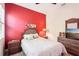 Bedroom features a red accent wall, a ceiling fan, and a window with blinds at 8057 Rio Bella Pl, Bradenton, FL 34201