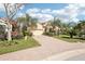 Charming single-story home with lush landscaping, mature palm trees, and a brick driveway at 8057 Rio Bella Pl, Bradenton, FL 34201