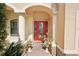 Inviting front entrance with a red door, columns, and charming potted plants, welcoming you home at 8057 Rio Bella Pl, Bradenton, FL 34201
