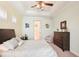 Elegant bedroom with tray ceiling, fan, and en-suite bathroom view, plus an upholstered chair and dresser at 8057 Rio Bella Pl, Bradenton, FL 34201