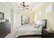 Bright bedroom featuring a tray ceiling, fan, and slider with views of the outdoor pool and lanai at 8057 Rio Bella Pl, Bradenton, FL 34201