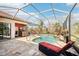 Relaxing outdoor pool area featuring a screened enclosure, comfortable seating, and a built-in bar at 8057 Rio Bella Pl, Bradenton, FL 34201
