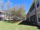 Exterior lawn view with lush landscape, mature trees, and condo building at 829 Lantern Way # 829, Clearwater, FL 33765