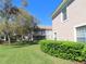 Exterior condo view showcasing landscaping, lawn, and a glimpse of neighboring buildings at 829 Lantern Way # 829, Clearwater, FL 33765