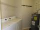 Functional laundry room with washer, dryer, water heater, and shelving at 829 Lantern Way # 829, Clearwater, FL 33765