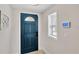 Inviting foyer showcasing a stylish blue front door, security system, and natural light at 922 Sago Palm Way, Apollo Beach, FL 33572