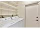 Functional laundry room featuring modern white washer and dryer units, and practical shelving at 922 Sago Palm Way, Apollo Beach, FL 33572