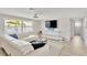 Comfortable living room featuring a white sectional sofa, large window, and entertainment center at 922 Sago Palm Way, Apollo Beach, FL 33572