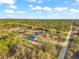 Aerial view of property with house, outbuildings and wooded boundary at 9580 Grove Rd, Brooksville, FL 34613