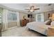 Bright bedroom features tile floor, wooden furniture set, ceiling fan, and two windows at 9580 Grove Rd, Brooksville, FL 34613