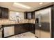 Functional kitchen featuring stainless steel appliances, tile backsplash, and ample countertop space at 9806 Gray Fox Ln, Port Richey, FL 34668