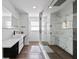 Sleek bathroom with glass shower, black fixtures, modern sink, and stylish tile; wood-look flooring enhances the space at 9826 La Vonda St, Riverview, FL 33569