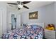 Bright bedroom featuring neutral gray walls and a floral patterned comforter at 9826 La Vonda St, Riverview, FL 33569