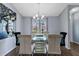 Dining room with chandelier, six chairs, glass table, tile floors, and a flower decor at 9826 La Vonda St, Riverview, FL 33569
