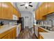 Galley kitchen showcasing ample wood cabinets, matching appliances, and wood-look flooring at 9826 La Vonda St, Riverview, FL 33569