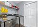 Modern laundry room with gray walls, wood floor, shelving, and new Samsung washer and dryer at 9826 La Vonda St, Riverview, FL 33569