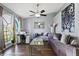Living room featuring tile floors, large windows, ceiling fan, modern furniture, and a decorative painting at 9826 La Vonda St, Riverview, FL 33569