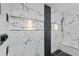 Stylish shower showcasing marble and stone tile, black trim, built-in shelving, and modern fixtures at 9826 La Vonda St, Riverview, FL 33569