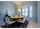 Dining room featuring a modern light fixture, an oval table, and a view of the front yard at 10411 Cory Lake Dr, Tampa, FL 33647