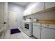 Well-equipped laundry room with abundant cabinet space, washer, and dryer at 10411 Cory Lake Dr, Tampa, FL 33647