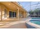 Spacious pool area with covered patio, surrounded by lush greenery and a screened enclosure at 10411 Cory Lake Dr, Tampa, FL 33647