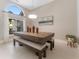 Elegant dining room with a modern table, bench seating, and a large arched window at 10408 Double Bayou Way, Tampa, FL 33615