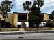 Inviting condo featuring a private balcony, neutral stucco facade, privacy fence, and tropical landscaping at 105 S Obrien St # 216, Tampa, FL 33609